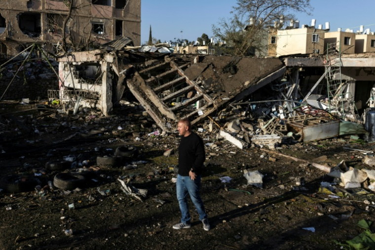 Un homme sur les lieux d'un tir de missile iranien à Dimona, dans le sud d'Israël, le 22 mars 2026 ( AFP / JOHN WESSELS )