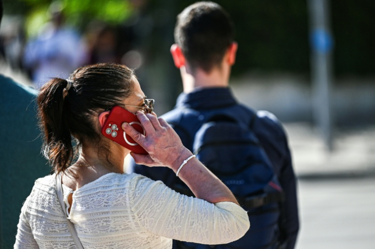 Une femme utilise son téléphone à Athènes, Grèce, le 3 avril 2024 ( AFP / Theophile Bloudanis )