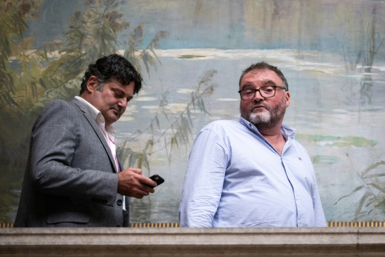 L'ancien anesthésiste français Frédéric Péchier (à droite) aux côtés de son avocat Randall Schwerdorffer pendant une pause lors de la première journée de son procès, au tribunal de Besançon, dans le nord-est de la France, le 8 septembre 2025 ( AFP / SEBASTIEN BOZON )