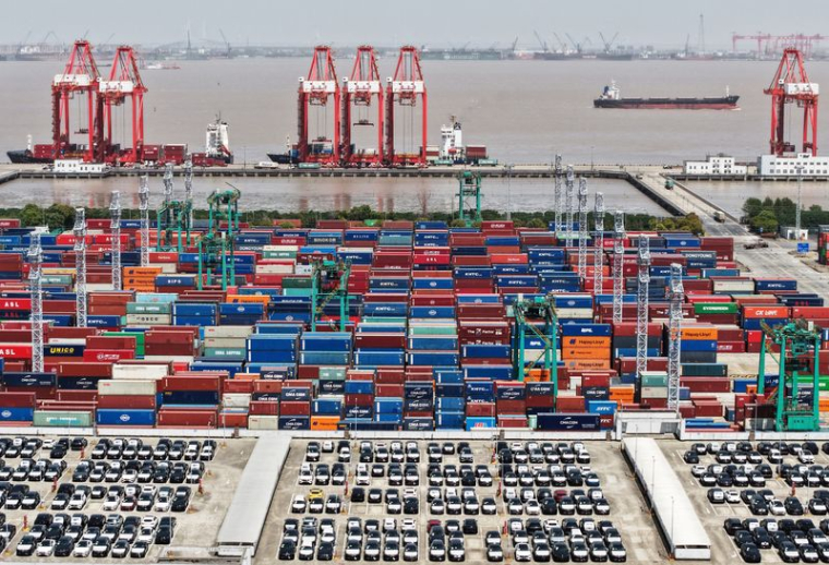 Une vue de drone montre des véhicules électriques (VE) destinés à l'exportation et des conteneurs dans un port de Shanghai