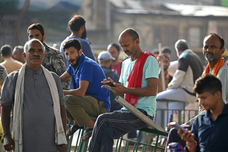 Des ouvriers migrants indiens attendant des clients à la recherche de main-d’œuvre journalière sur un marché de Srinagar, le 24 août 2026 ( AFP / Tauseef MUSTAFA )