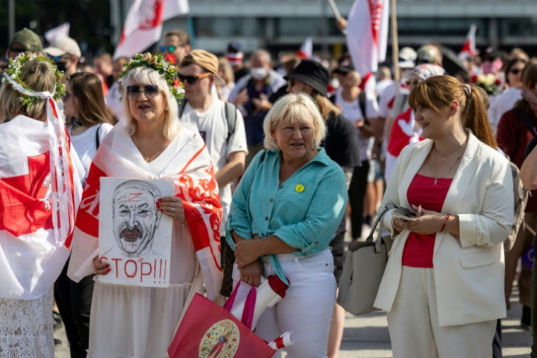 L'opposante Antanina Kanavalava (d) et sa mère Hanna (c) participent à une manifestation de l'opposition bélarusse en exil, le 9 août 2025 à Varsovie, en Pologne ( AFP / Wojtek RADWANSKI )