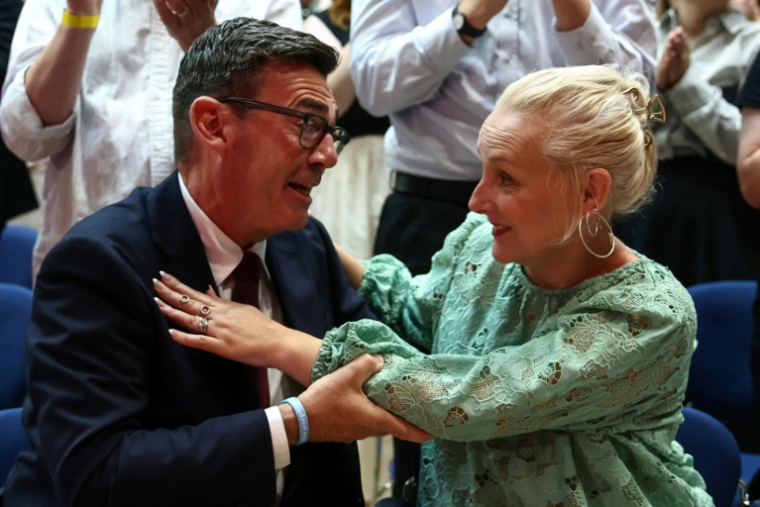 Andy Burnham (g) serre dans ses bras son épouse Marie-France van Heel (d) après avoir été confirmé comme nouveau chef du Parti travailliste et prochain Premier ministre, lors de la conférence extraordinaire du Labour à Londres, le 17 juillet 2026 ( POOL / Henry NICHOLLS )