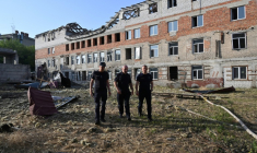 Des secouristes devant un immeuble résidentiel endommagé par une attaque de drone russe, dans le centre de Kharkiv, le 11 juillet 2025 en Ukraine ( AFP / SERGEY BOBOK )