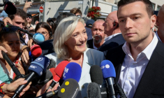 Marine Le Pen (c), cheffe du groupe parlementaire Rassemblement national (RN) et candidate à la présidentielle de 2027, et Jordan Bardella, président du RN, entourés de journalistes à leur arrivée à La Flèche pour un rassemblement de campagne, le 8 juillet 2026 dans la Sarthe ( AFP / FRED TANNEAU )