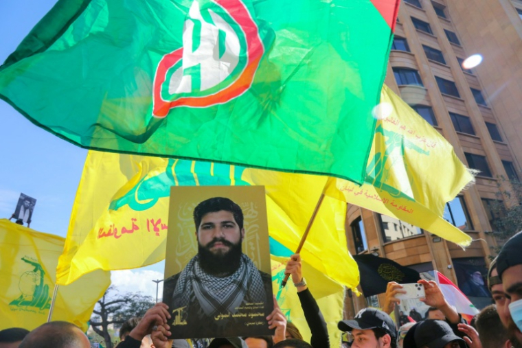 Des partisans du Hezbollah manifestent à Beyrouth, l'un d'eux brandit le portrait d'un membre tué.  ( AFP / Ibrahim AMRO )