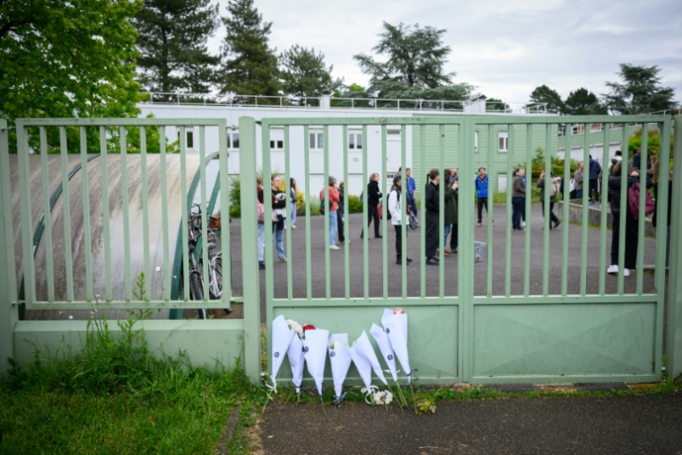 Des fleurs déposées devant la grille du collège Libertaire Rutigliano en hommage à l'adolescent de 15 ans tué lors d'une fusillade, le 18 mai 2026 à Nantes ( AFP / Loic VENANCE )