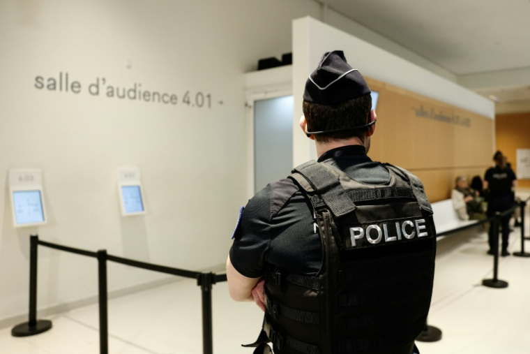 Un policier devant une salle d'audience au palais de justice de Paris, avant le procès d'un animateur d'une école parisienne poursuivi pour agressions sexuelles sur mineurs, le 5 mai 2026 ( AFP / Kenzo TRIBOUILLARD )