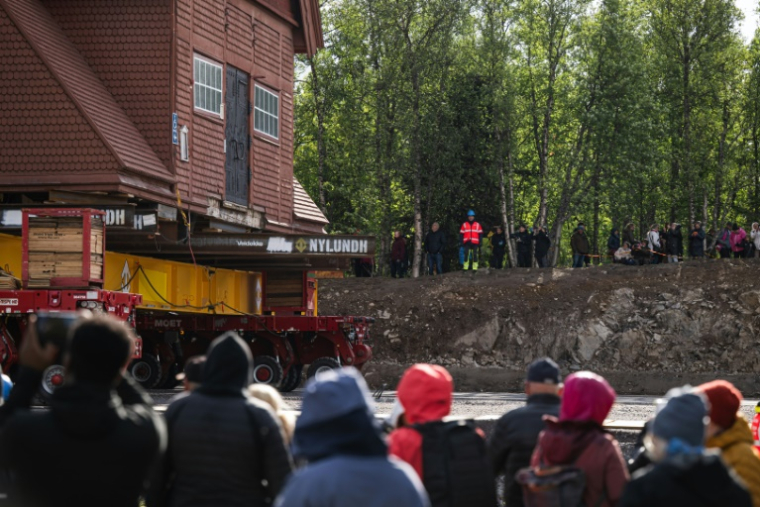Des personnes assistent au déplacement de l'église en bois de Kiruna, le 16 août 2025 à Kiruna, en Suède ( AFP / Jonathan NACKSTRAND )