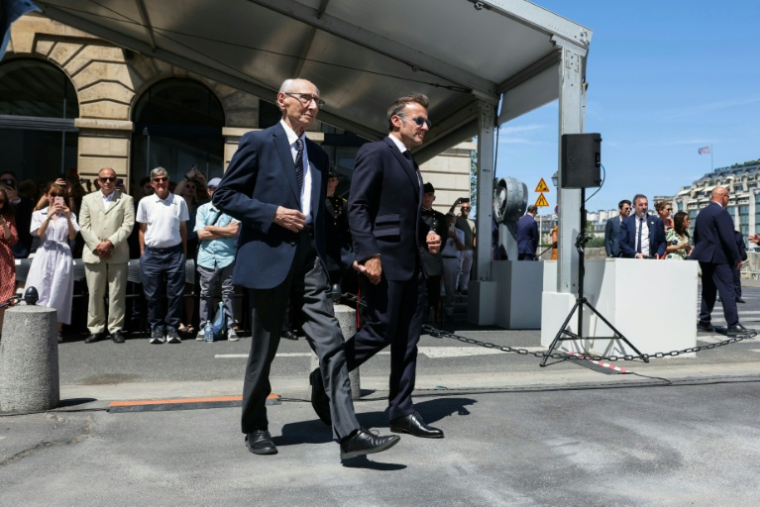 Le président français Emmanuel Macron (D) tient la main de Charles Dreyfus, petit-fils d'Alfred Dreyfus, le 12 juillet 2026, lors de la première journée nationale de commémoration de la reconnaissance de l'innocence du capitaine Dreyfus, officier juif injustement condamné pour haute trahison dans un profond climat antisémite à fin du 19e siècle ( POOL / Thomas SAMSON )
