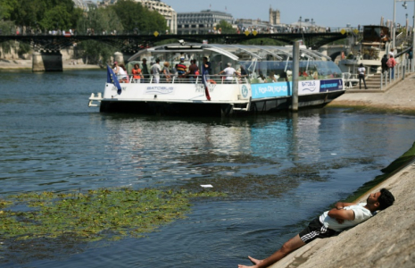 Un homme se rafraîchit sur une berge de la Seine, à Paris, alors qu'une vague de chaleur frappe la France, le 19 juin 2025 ( AFP / Thomas SAMSON )