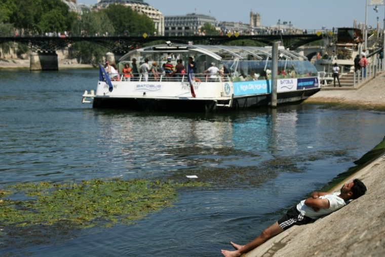 Un homme se rafraîchit sur une berge de la Seine, à Paris, alors qu'une vague de chaleur frappe la France, le 19 juin 2025 ( AFP / Thomas SAMSON )