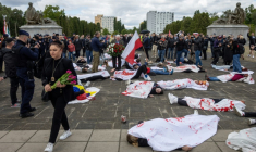 Des manifestants allongés sur le sol, simulent des corps de victimes, pour protester contre l'invasion russe de l'Ukraine, au mausolée des soldats soviétiques à Varsovie, en Pologne, le 9 mai 2025 ( AFP / Wojtek RADWANSKI )