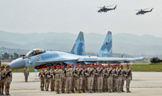 Des troupes russes, un chasseur Su-35 et des hélicoptères Mi-24, lors d'un défilé à la base de Hmeimim, en mai 2021 ( SANA / - )