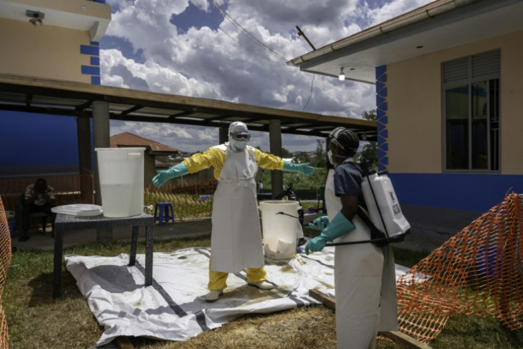Un soignant de l'ONG Médecins Sans Frontières (MSF) du centre anti-Ebola de la clinique Elikya est aspergé de désinfectant en quittant la zone réservée aux malades d'Ebola, à Bunia, dans l'est de la République démocratique du Congo, le 5 juin 2026 ( AFP / GLODY MURHABAZI )