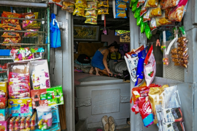Priscilla Buan nettoie le mausolée dans lequel elle vit avec sa famille, dans le cimetière Nord de Manille, le 21 octobre 2025 ( AFP / Jam STA ROSA )