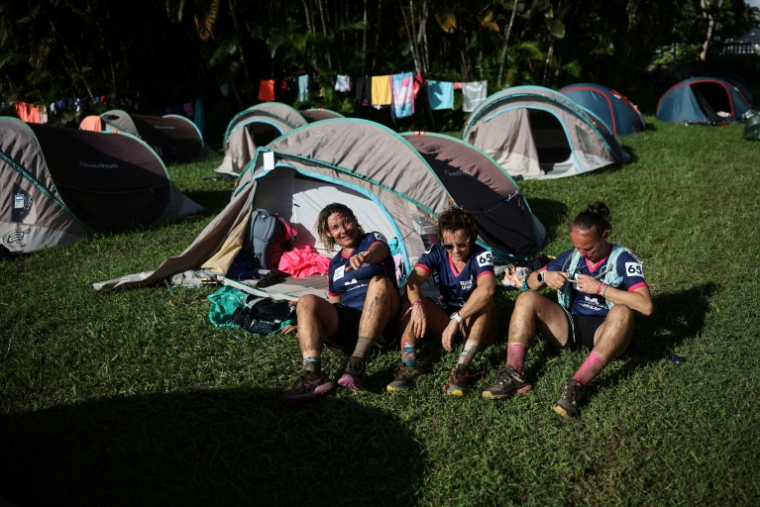 Sonia Latapie (d), souffrant d'insuffisance rénale et atteinte d'un cancer du sein, membre de l'équipe "Les Reines du cœur", avec ses coéquipières Carole Loussalez (c) et Alexia Elineau (g) au campement du Château Depaz, près de Saint-Pierre, après avoir participé à une course de trail du "Raid des Alizés", le 28 novembre 2025 en Martinique ( AFP / Anne-Christine POUJOULAT )