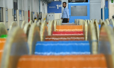 Un employé passe devant des câbles de fibre optique dans l'usine de Sterlite Technologies Limited (STL) à Chhatrapati Sambhaji Nagar, dans l'Etat de Maharashtra, en Inde, le 9 juillet 2026 ( AFP / Indranil MUKHERJEE )