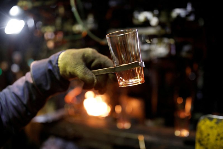 Photo d'archives d'un employé tenant un verre alors qu'il travaille dans une usine près d'Orléans en France
