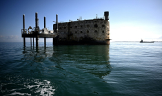 Une barge effectue des travaux de terrassement à proximité du Fort Boyard qui menace de s'écrouler, au large de l'île d'Aix dans l'océan Atlantique, le 16 juillet 2025 en Charente-Maritime ( AFP / Christophe ARCHAMBAULT )