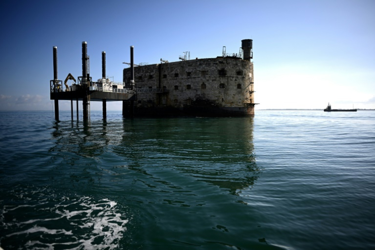 Une barge effectue des travaux de terrassement à proximité du Fort Boyard qui menace de s'écrouler, au large de l'île d'Aix dans l'océan Atlantique, le 16 juillet 2025 en Charente-Maritime ( AFP / Christophe ARCHAMBAULT )