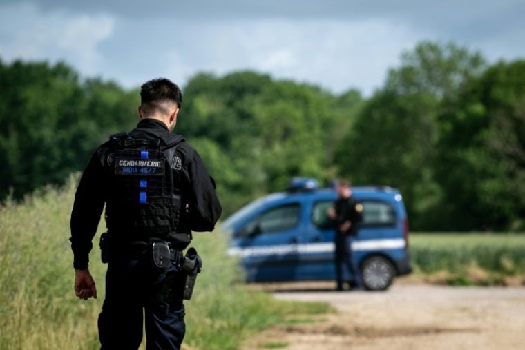 Des gendarmes forment un périmètre de sécurité autour de la zone où de nouvelles fouilles sont en cours pour retrouver d'éventuelles traces des victimes d'Emile Louis, à Rouvray, dans l'Yonne, le 26 mai 2025 ( AFP / ARNAUD FINISTRE )