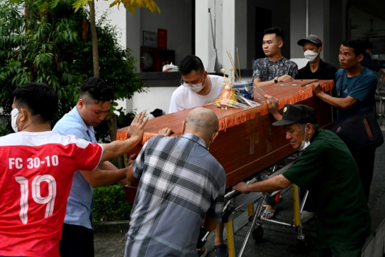 Des proches autour du cercueil d'une des victimes du naufrage d'un bateau de tourisme qui a fait au moins 35 morts dans la province vietnamienne côtière de Quang Ninh, le long de la Baie d'Halong, le 20 juillet 2025 ( AFP / Nhac NGUYEN )