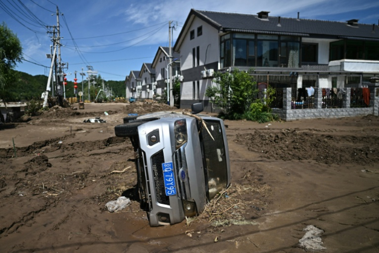 Une voiture accidentée après les pluies diluviennes qui se sont abattues dans le nord de la Chine, dans les rues du district de Huairou, à Pékin, le 30 juillet 2025 ( AFP / Pedro Pardo )