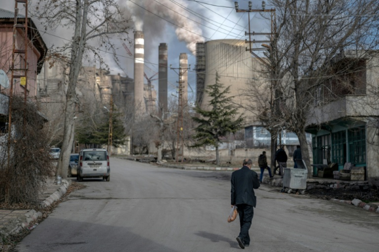 Des habitants dans une du village de Cogulhan où des nuages de fumée s'élèvent de la centrale électrique au charbon d'Afsin-Elbistan, le 11 février 2026 en Turquie ( AFP / Ozan KOSE )