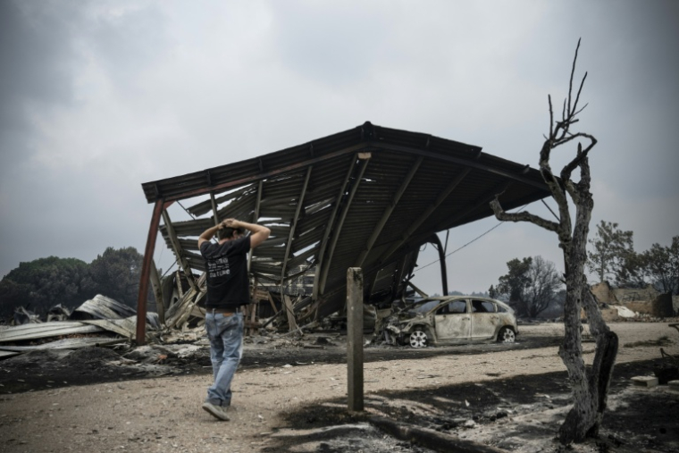 Un habitant inspecte les dégâts dans une zone résidentielle brûlée après un incendie de forêt à Le Porge, dans le département de la Gironde, dans le sud-ouest de la France, le 25 juillet 2026 ( AFP / JULIEN DE ROSA )