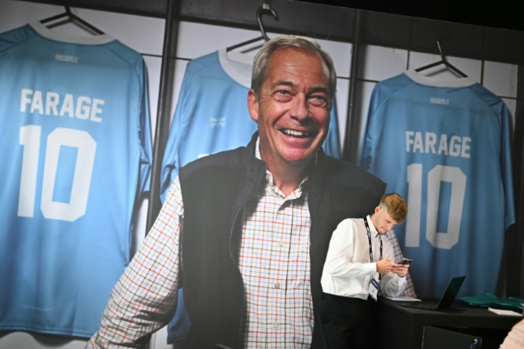 Une grande affiche du leader du parti Reform UK, Nigel Farage, au premier jour de la conférence du parti à Birmingham, dans le centre de l'Angleterre, le 5 septembre 2025 ( AFP / Oli SCARFF )