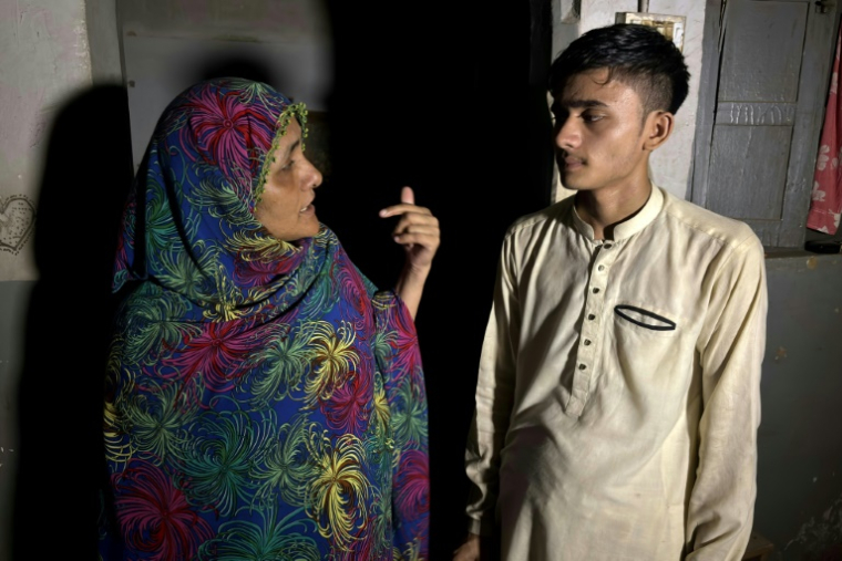 Maryam Suleman et son fils Ahmed Raza, tous deux non inscrits à l'état-civil, dans leur maison à Karachi, le 19 juin 2025 au Pakistan ( AFP / Rizwan TABASSUM )