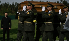 Le président ukrainien Volodymyr Zelensky (g) participe à la cérémonie de réinhumation du leader nationaliste controversé Andriï Melnyk, décédé en 1964 et ancien chef d'une branche de l'Organisation des nationalistes ukrainiens (OUN), ainsi que de son épouse Sofia, au cimetière national militaire commémoratif près de Kiev, le 25 mai 2026 ( AFP / Genya SAVILOV )