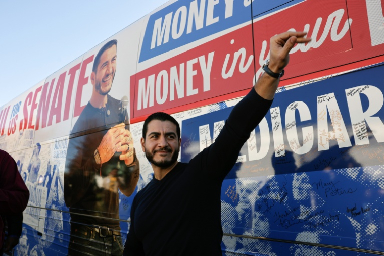 Le candidat démocrate pour un siège au Sénat dans le Michigan, Abdul El-Sayed, fait signe à des partisans près de son bus de campagne à Flint, le 18 octobre 2026 ( AFP / JEFF KOWALSKY )
