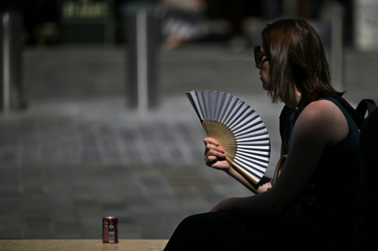 Une passante utilise un éventail dans les rues de Bordeaux pendant un épisode de canicule le 25 juin 2026 ( AFP / Christophe ARCHAMBAULT )