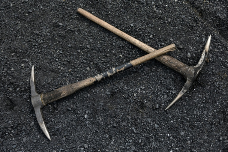 Des pioches sur un lit de fragments de charbon, près de l'entrée de la mine illégale Golfview, à Ermelo, en Afrique du Sud, le 25 septembre 2025 ( AFP / EMMANUEL CROSET )