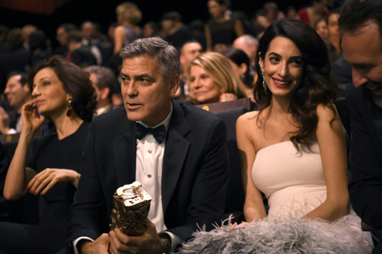 Au centre de l'image George Clooney et son épouse Amal Clooney lors de la cérémonie des César à Paris le 24 février 2017 ( AFP / bertrand GUAY )