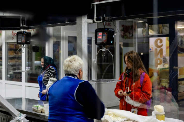 Anastassiia Jmoutska achète du fromage dans un supermarché, après son travail, le 13 octobre 2026 à Kiev, en Ukraine ( AFP / Tetiana DZHAFAROVA )