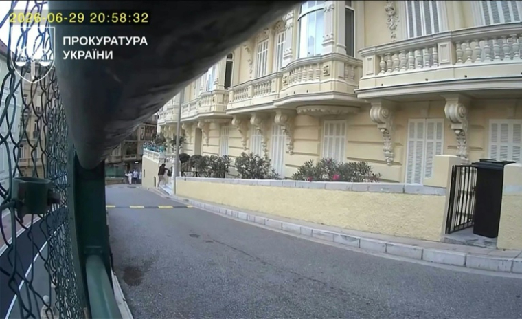 Image tirée d'une vidéo de surveillance du 29 juin 2026, publiée par le bureau du procureur général d'Ukraine le 17 juillet 2026, montrant une personne déposant un sac à l'entrée d'une résidence, quelques instants avant l'attentat au colis piégé survenu à Monaco qui a blessé l'homme d'affaires d'origine ukrainienne Vadim Ermolaev, sa compagne et son fils adolescent ( Ukraine's Prosecutor General's Office / - )