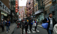 Des touristes et des piétons se promènent dans Pell Street, dans le quartier de Chinatown à Manhattan, à New York