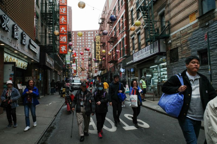 Des touristes et des piétons se promènent dans Pell Street, dans le quartier de Chinatown à Manhattan, à New York