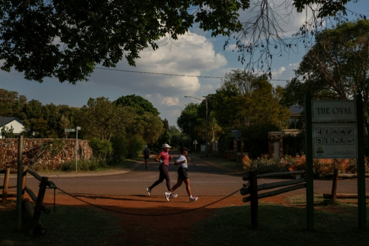 Nancy Masha (D) et Babalwa Melitafa (G) font leur jogging dans un lotissement sécurisé à Irene, près de Pretoria, en Afrique du Sud, le 21 septembre 2026 ( AFP / PHILL MAGAKOE )
