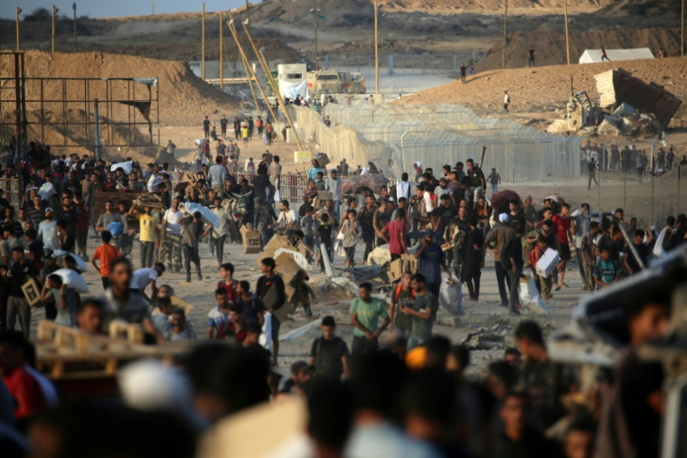Des Palestiniens rassemblés à un point de distribution d'aide de la Fondation humanitaire de Gaza (GHF), près du camp de réfugiés de Nousseirat, dans le centre de la bande de Gaza, le 25 juin 2025 ( AFP / Eyad BABA )