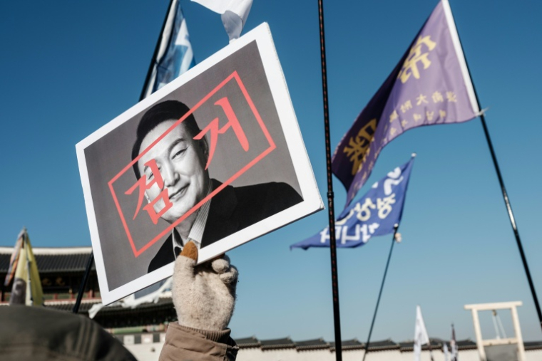 Un manifestant marche avec un portrait du président sud-coréen Yoon Suk Yeol avant un rassemblement à Séoul, le 11 janvier 2025 ( AFP / YASUYOSHI CHIBA )