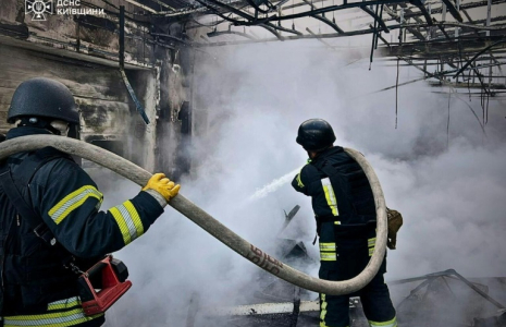 Photo diffusée par le service d'urgence de l'État ukrainien, le 18 mai 2025, de sauveteurs éteignant un incendie dans un bâtiment à la suite d'attaques de drones russes sur la région de Kiev ( Service d'urgence de l'État ukrainien / Handout )