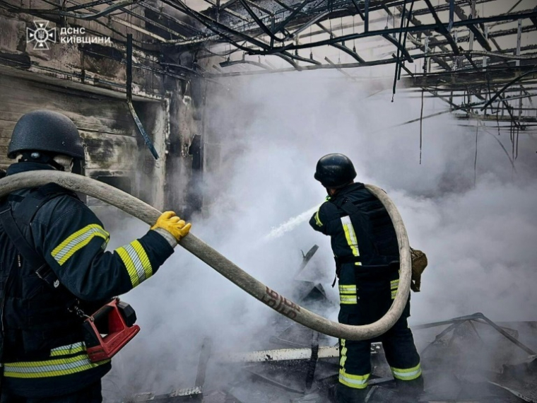 Photo diffusée par le service d'urgence de l'État ukrainien, le 18 mai 2025, de sauveteurs éteignant un incendie dans un bâtiment à la suite d'attaques de drones russes sur la région de Kiev ( Service d'urgence de l'État ukrainien / Handout )