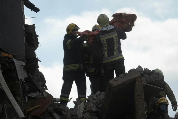 Des secouristes transportent le corps d'un enfant extrait des décombres d'un immeuble résidentiel touché par une frappe aérienne russe à Prylouky, le 7 octobre 2026 dans le nord de l'Ukraine ( AFP / Genya SAVILOV )