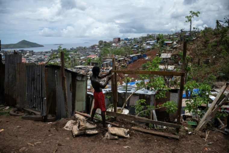 Un homme fait des réparations, quelques jours après le passage du cyclone Chido, dans le quartier de Cavani, à Mamoudzou, le 2 janvier 2025 ( AFP / JULIEN DE ROSA )