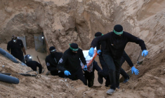 Des combattants armés et cagoulés du Hamas transportent un corps retrouvé dans un tunnel au nord de Khan Younès, dans le sud de la bande de Gaza, le 28 octobre 2025  ( AFP / Bashar TALEB )
