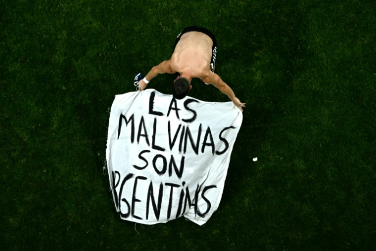 Le milieu de terrain argentin Giovani Lo Celso déploie sur la pelouse une banderole proclamant: "Les Malouines sont argentines", à l'issue de la demi-finale du Mondial 2026 contre l'Angleterre, le 15 juillet 2026 à Atlanta  ( AFP / Jewel SAMAD )